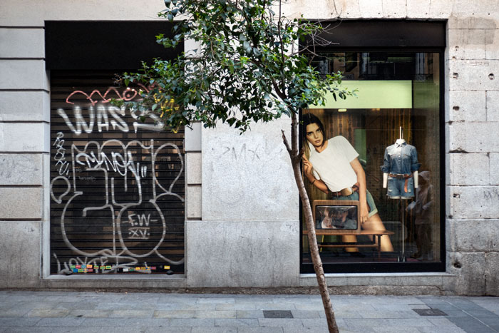 Publicidad chica apoyada en escaparate tienda moda Madrid moda Madrid fotografia serie Moneda Viviente subvertising contrapublicidad la jovencita situacionismo critica social Klossowski Antonio Beltrn